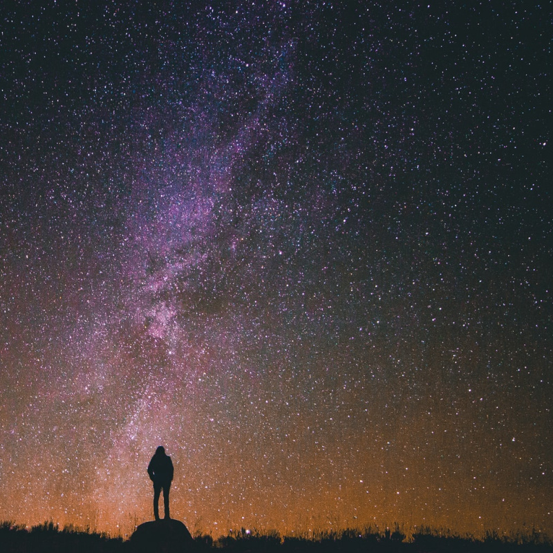 Person observing the Milky way, Unsplash photo by Greg Rakozy